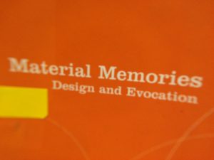 an otange rectangle with a small yellow rectangle and the words 'Material Memories, design and evocation' written in white