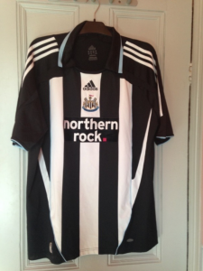 a black and white striped football shirt hanging on the back of a door