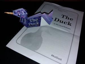 an origami duck sitting on top of a theatre playbill